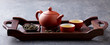 Green tea oolong in teapot and chawan bowls, cups on a wooden tray. Grey background.
