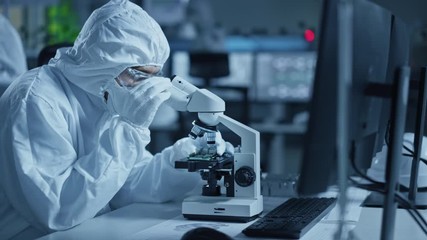 Poster - Research Factory Cleanroom: Engineer / Scientist wearing Coverall, Gloves Uses Microscope to Inspect Samples, Developing High Tech Modern Technology for Medical and High Precision Electronics Industry