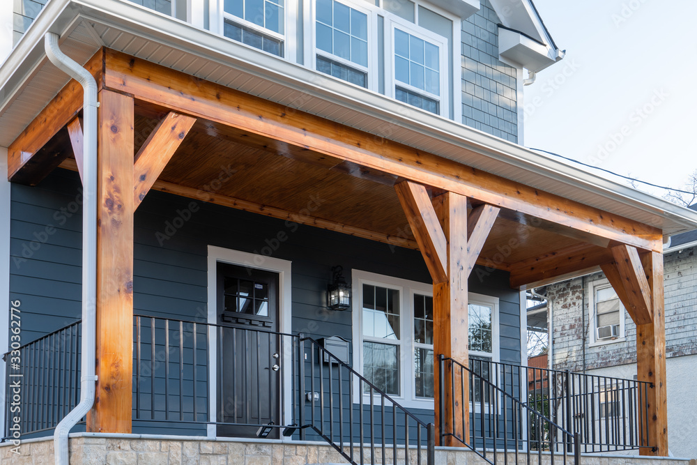 Newly restored single family home with beautiful covered porch held up by cedar wood beams. Black metal railings with balusters