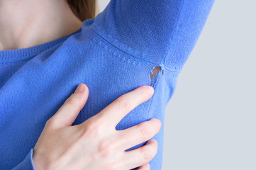 A hole in blue clothes. Caucasian woman in sweatshirt.