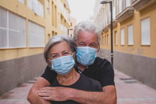 Couple Of Two Seniors Wearing Medical Mask To Prevent Coronavirus (covid-19) Or Another Type Of Virus - Close Up Of Faces In Middle Of Street -  Protect People Satying Safe Together - Italian People