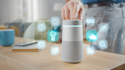 Man Turns On Smart Speaker with Active Artificial Intelligence Assistant with Futuristic Screenless Interface with Different Icons and Symbols.