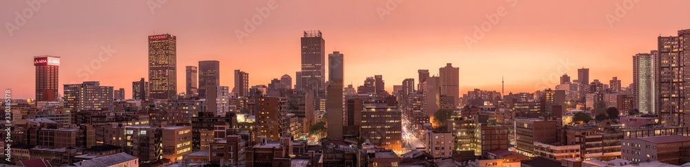 A beautiful and dramatic panoramic photograph of the Johannesburg city skyline, taken on a golden evening after sunset. - obrazy, fototapety, plakaty 