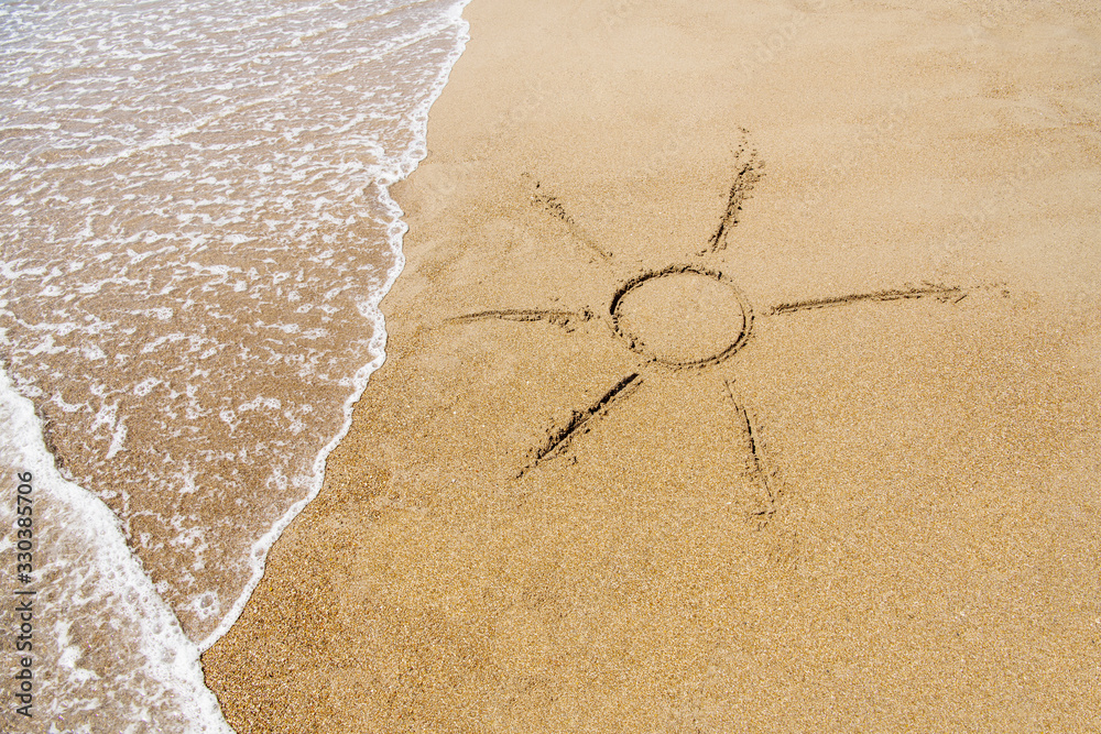 The symbol of the sun drawing on the sand. - obrazy, fototapety, plakaty 