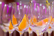 glasses with an orange slice set in several rows prepared for preparing drinks, close-up