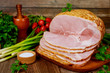 © Olesya - Smoked boneless ham with vegetables and salt on wooden table.