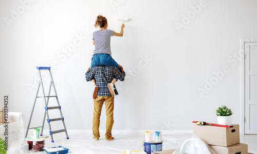 Fotografía Anonymous happy couple make renovating painting wall at home.