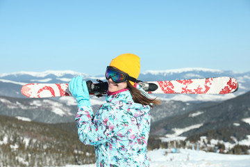 Sticker - Young woman with ski equipment in mountains. Winter vacation