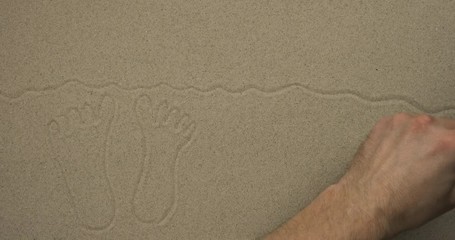 Sticker - Drawing with a stick on the sand. Feet on the beach against the background of the sun and seagulls.