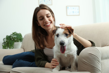 Canvas Print - Young woman with her cute Jack Russell Terrier on sofa at home. Lovely pet