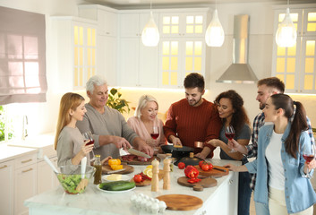 Happy people cooking food together in kitchen