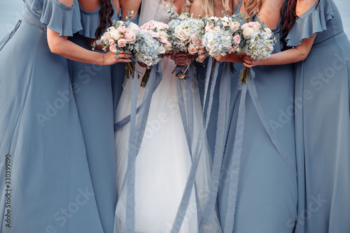 Cuadros en Lienzo Beautiful blue dridesmaids dresses and bride with fresh hydrangea bouquets