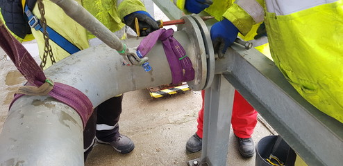 riggers move the pipe using two chain blocks