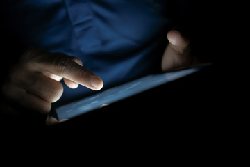 Close up of man hand use digital tablet at night 