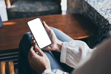 Mockup image blank white screen cell phone.woman hand holding texting using mobile on desk at coffee shop.background empty space for advertise text.people contact marketing business,technology