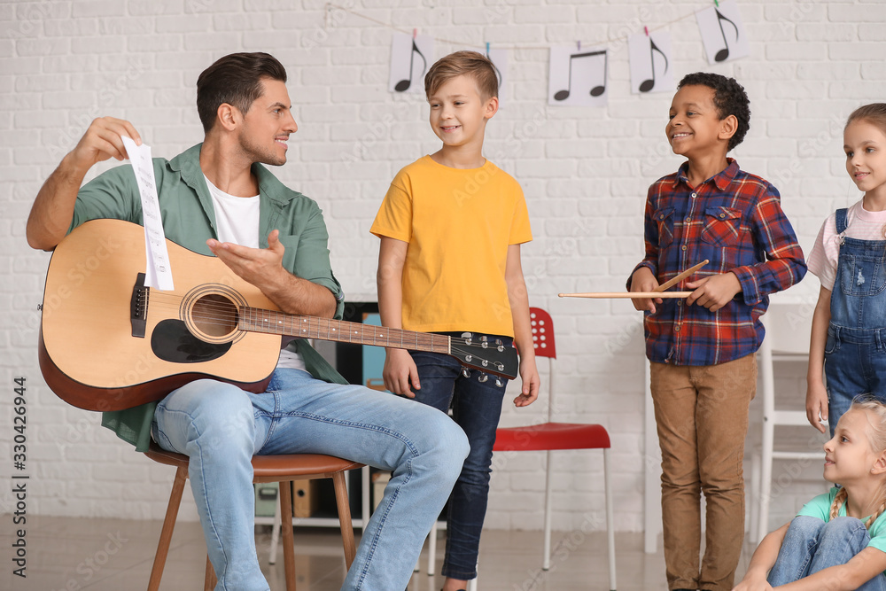Teacher giving music lessons at school