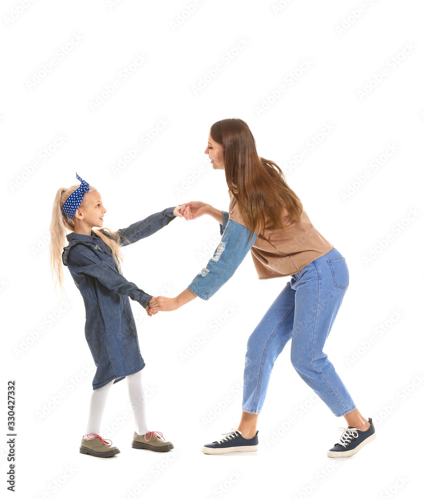 Woman and her little daughter dancing against white background