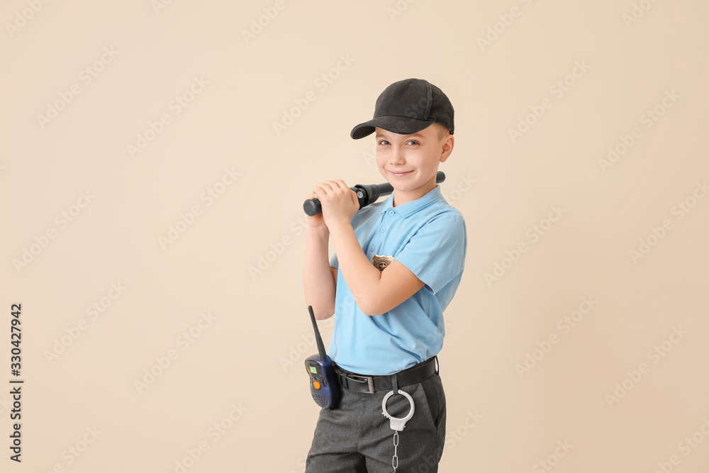 Cute little police officer on color background