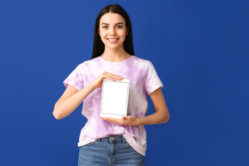 Poster - Beautiful young woman with tablet computer on color background