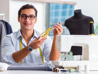 Young man tailor working on new clothing