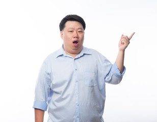 Wall Mural - Asian Fat Man in blue shirt pointing to copyspace with doubts face isolated on white background.