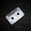 black audio cassette on a wooden background. vintage