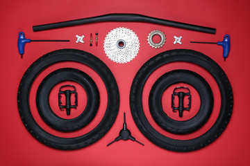 Canvas Print - Set of different bicycle tools and parts on red background, flat lay