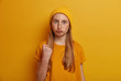 © WHstudio Leushin N - Portrait of emotional angry teenage girl shows fist, threatens you, pouts lips and has widely opened eyes, wears bright yellow clothes, poses indoor. Furious child gestures indoor. Childhood concept