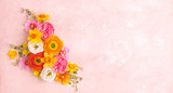 Holiday concept with spring flowers on pastel pink background