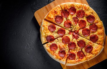 Wall Mural - Pepperoni Pizza with Mozzarella cheese, salami, Tomato sauce, pepper, Spices. Italian pizza on Dark grey black slate background