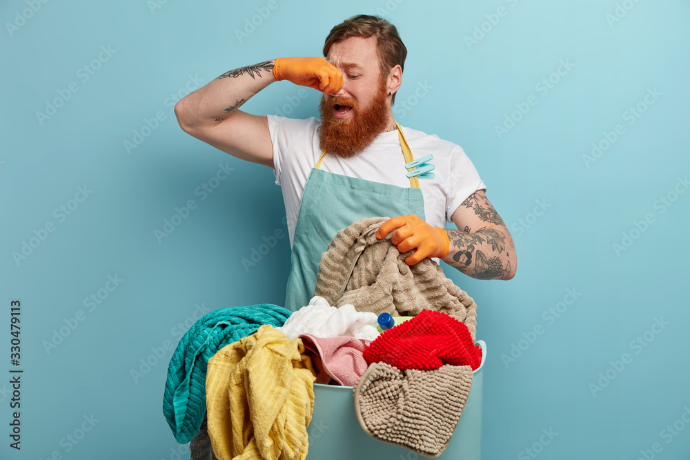Foto stock di Redhead man covers nose, feels bad smell, disgusting ...