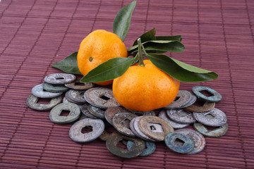 Canvas Print - Mandarin oranges and ancient Chinese coins on bamboo background. Symbols of luck and Chinese New Year.