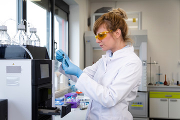 Wall Mural - Scientist taking cbd samples from chromatography machine in laboratory