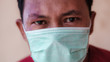 Asian man wearing a medical face mask to anticipate the spread of diseases caused by viruses, such as coronavirus or covid-19 and avian influenza, which become a world pandemic.