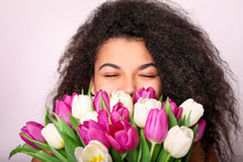 Young African Woman With Flowers On White Background. Women's Day Concept