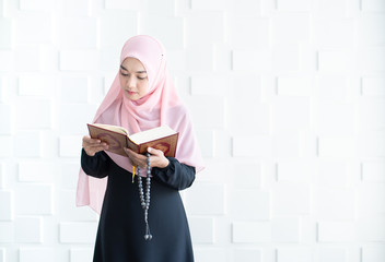 Beautiful young asian muslim woman reading quran