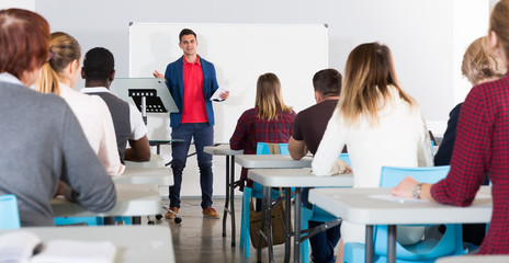 Wall Mural - Male student answering at whiteboard