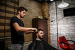 © AJ_stock_photos - a brutal-looking Barber cuts the hair of an Indian guy. cinematic image