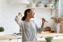 Excited Funny Girl Singing Into Whisk, Having Fun In Modern Kitchen At Home, Happy Girl Holding Beater As Microphone, Dancing, Listening To Music, Having Fun With Kitchenware, Preparing Breakfast