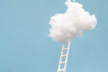 Ladder Leading Up To A Puffy Cotton Cloud On A Blue Background.