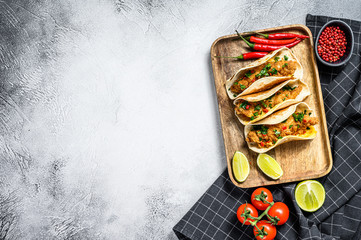 Wall Mural - Tacos with crispy chicken, parsley, cheese and chili peppers. White background. Top view. Copy space
