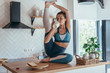 © undrey - Young woman drinks milk and does a stretching exercise.