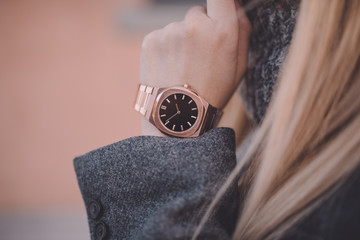 Elegant rose gold watch on woman hand, close-up.