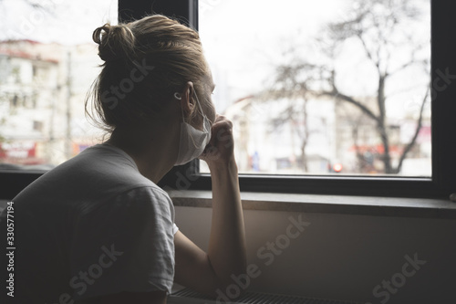 Fotografía woman with protection medical face mask by the window