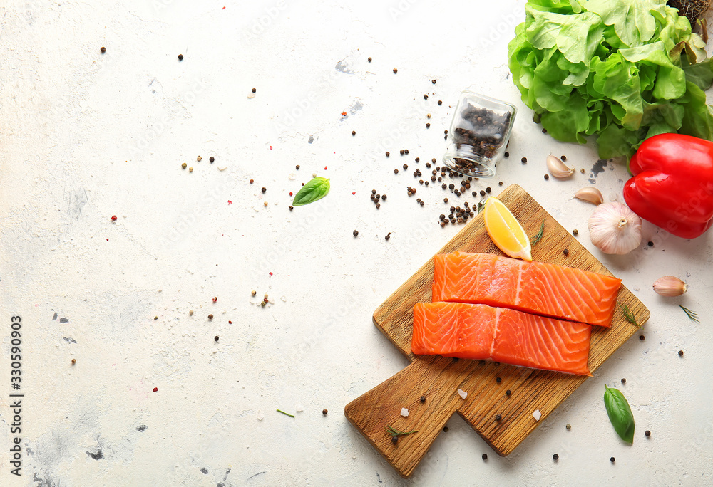 Raw salmon fillet with vegetables and spices on white background