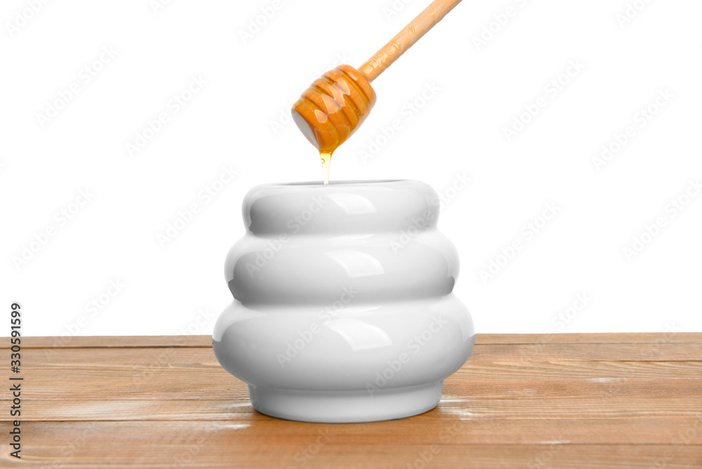 Jar with sweet honey on table against white background