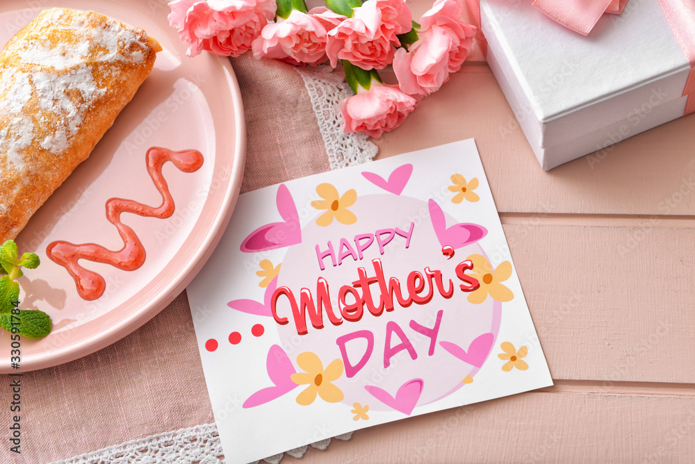 Card with text "Happy Mother's day", tasty breakfast and gift on table