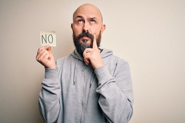 Poster - Handsome bald man with beard holding reminder paper with negative message serious face thinking about question, very confused idea