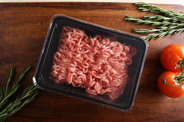 minced meat in packing on a wooden background