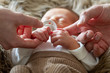 Vater und Mutter halten die Hände ihres Neugeborenen 